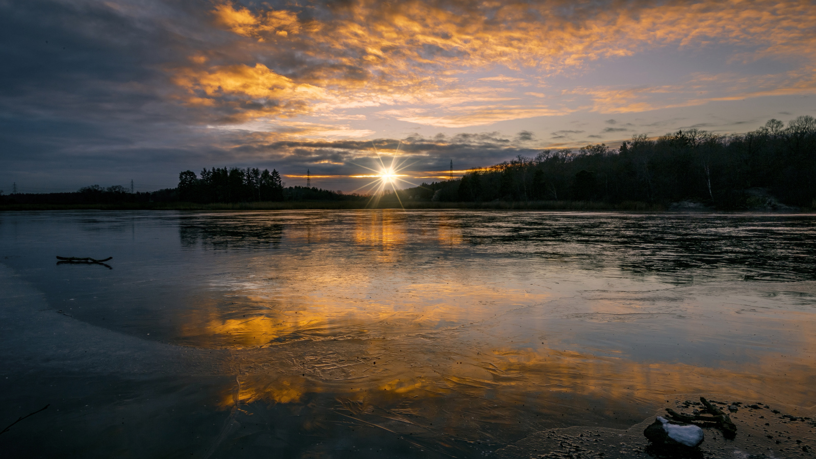 Рассвет холодного солнца над заледеневшим озером
