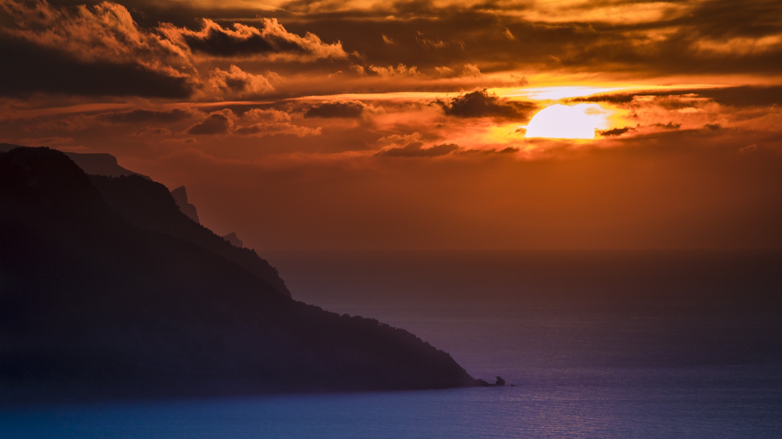 Туманный закат солнца над океанской гладью 