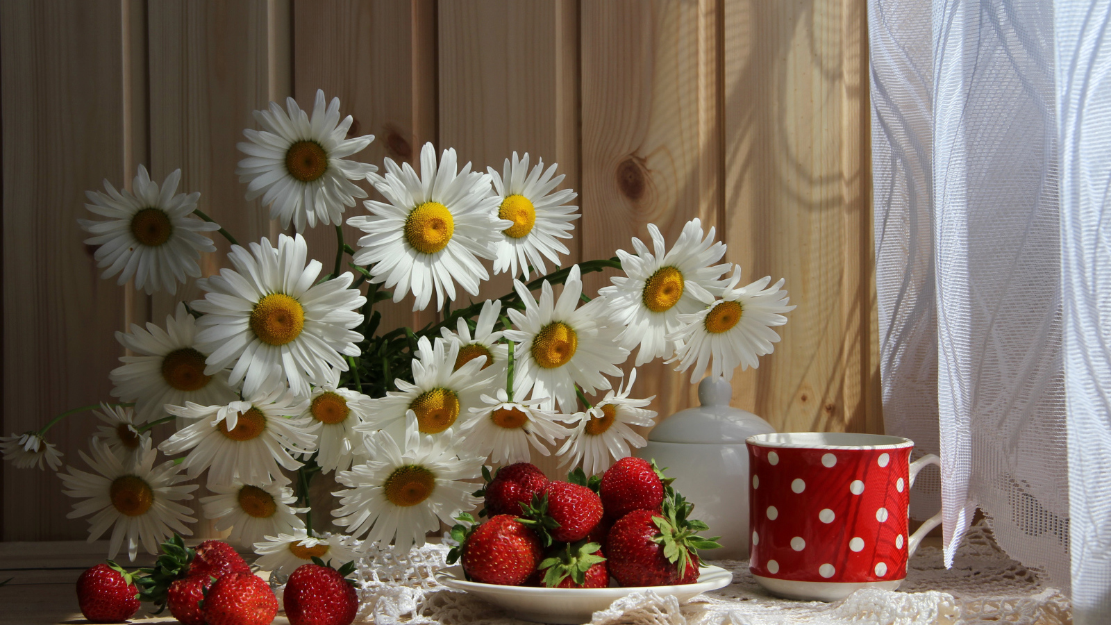 Букет белых ромашек на столе с клубникой