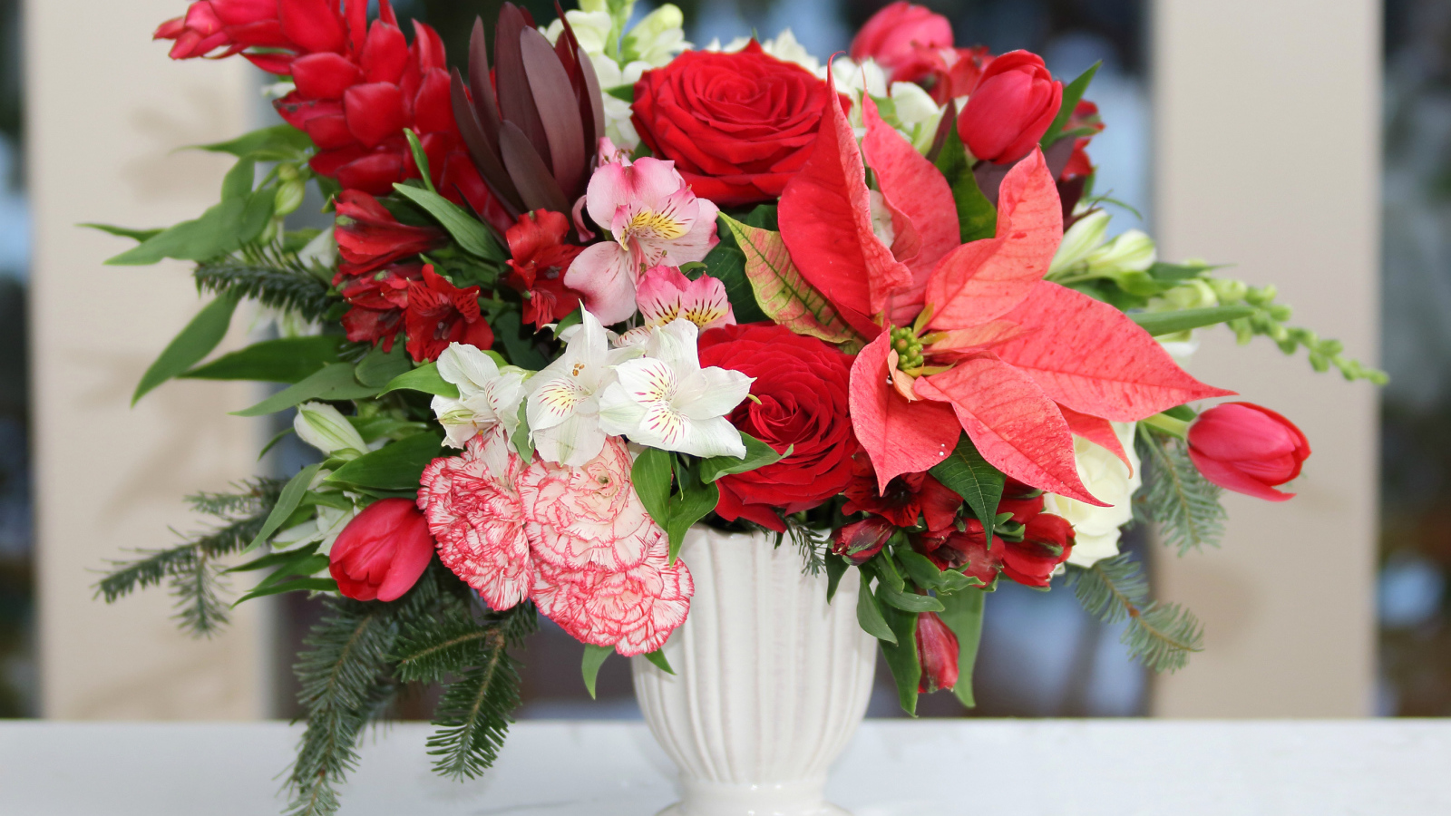 Розы, альстрёмерия, тюльпаны, гвоздики и молочай в красивом букете в белой вазе