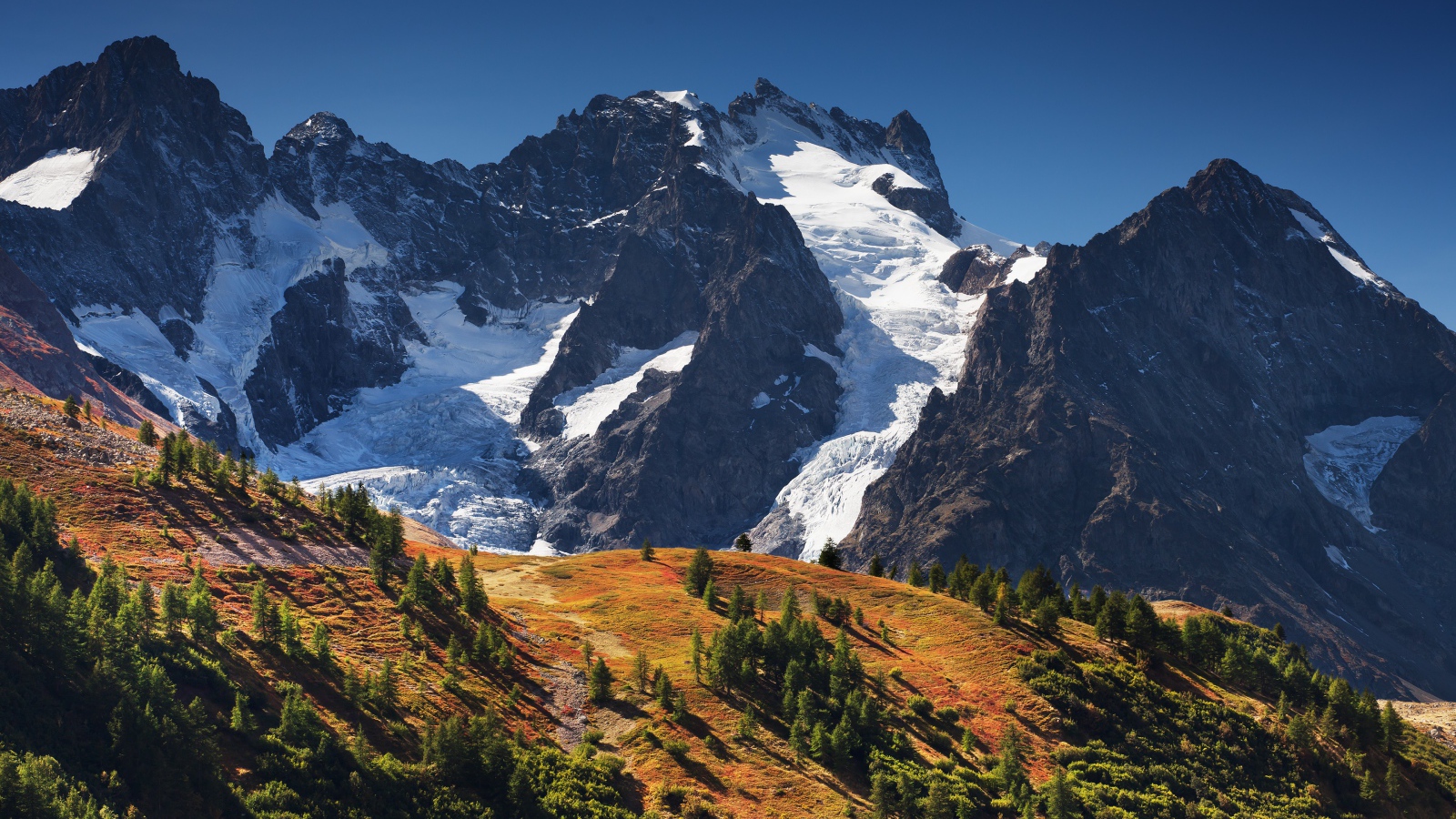Заснеженные горы на фоне голубого неба 