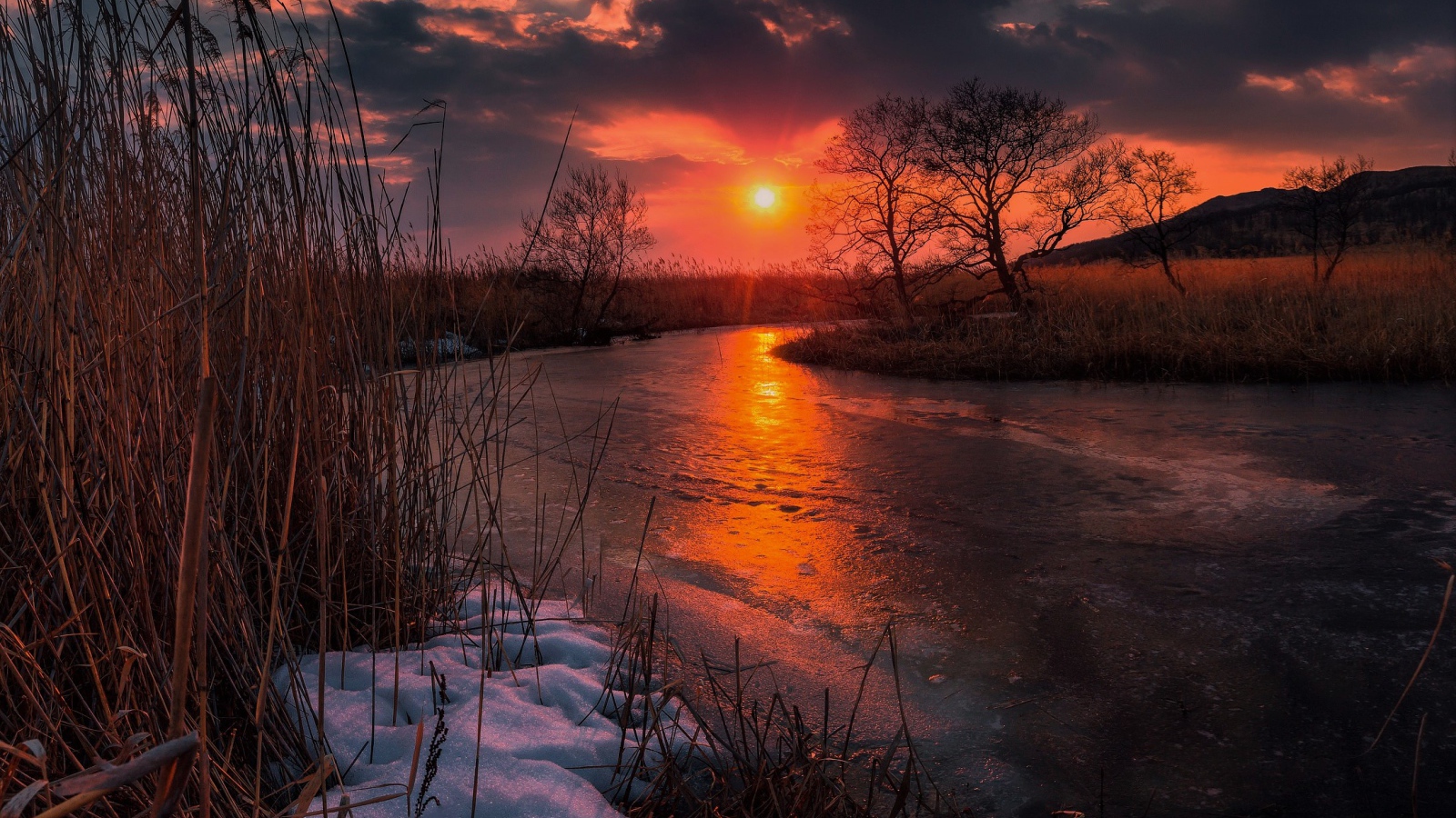 Закат солнца над покрытой льдом рекой