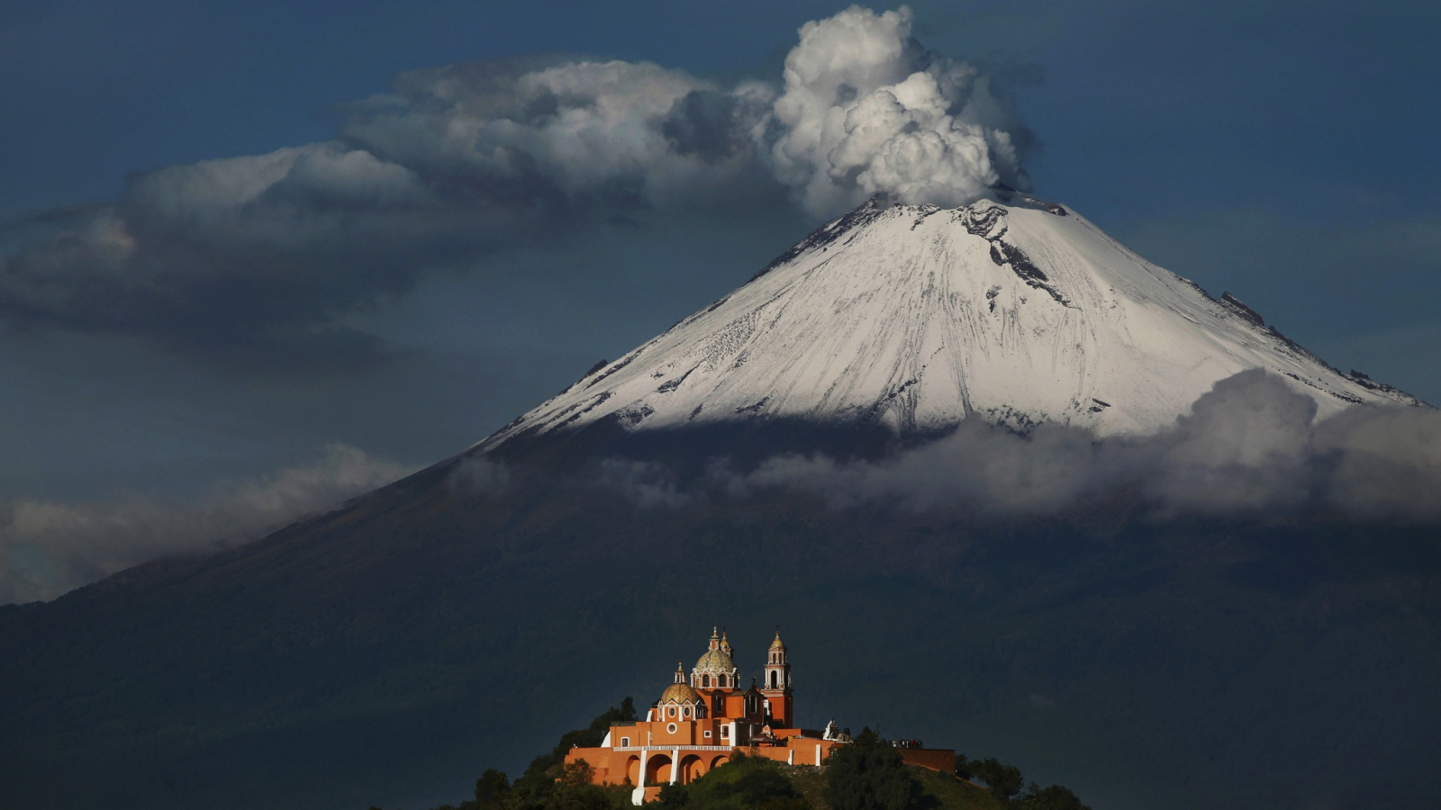 Дымящаяся вершина вулкана Попокатепетль в лучах солнца 