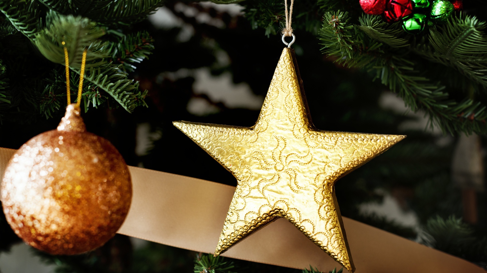 Золотая звезда и шар на новогодней елке