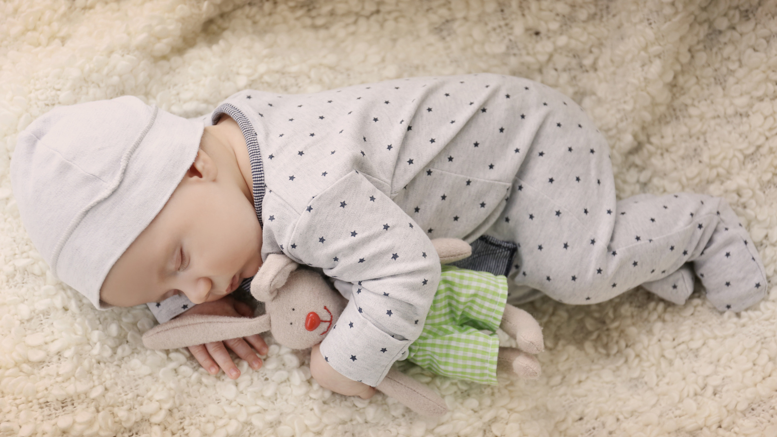 Грудной ребенок спит с любимой мягкой игрушкой