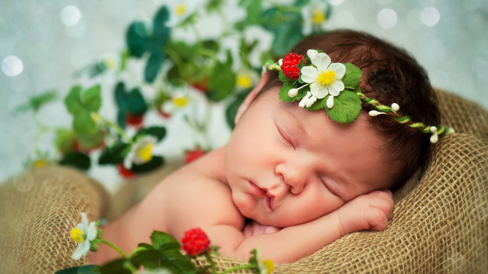 Спящий грудной ребенок с красивой повязкой на голове