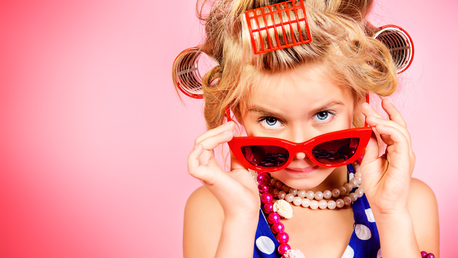 Гламурная девочка в больших красных очках и бигудями на голове