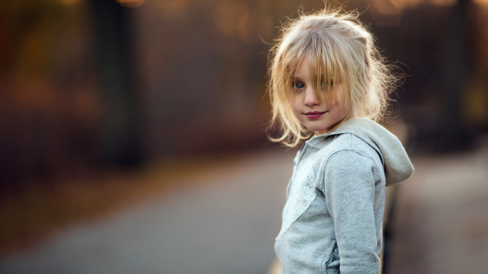 Маленькая девочка блондинка в серой кофте