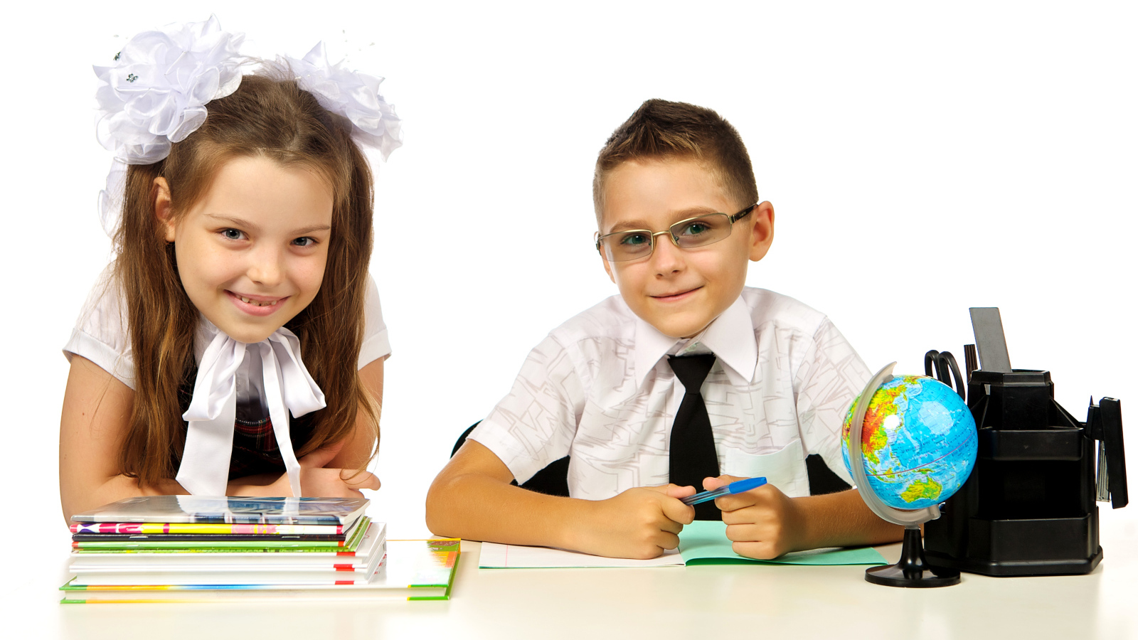 Маленькие мальчик и девочка школьники на белом фоне