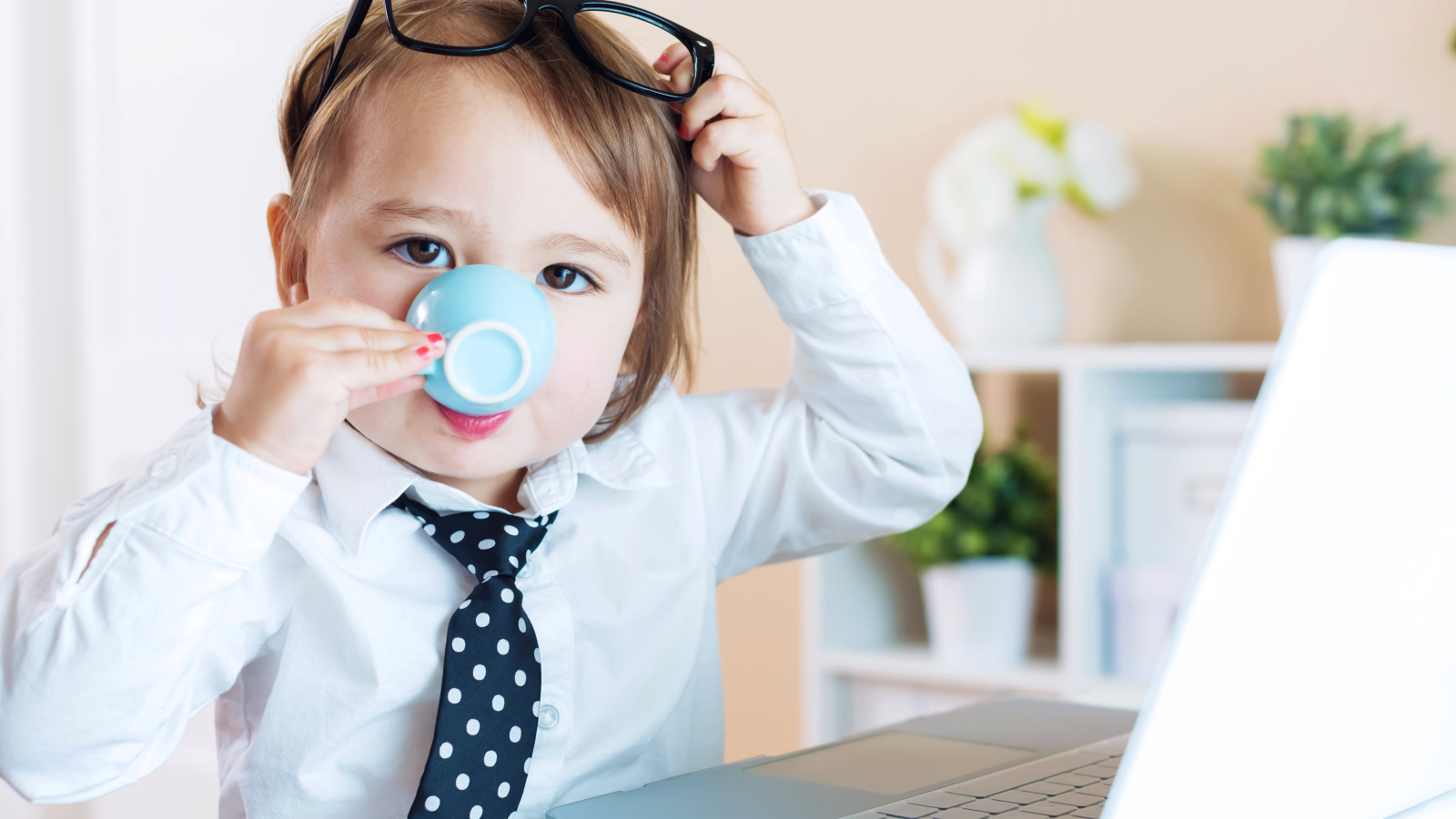 Маленький мальчик в деловом костюме и с чашкой