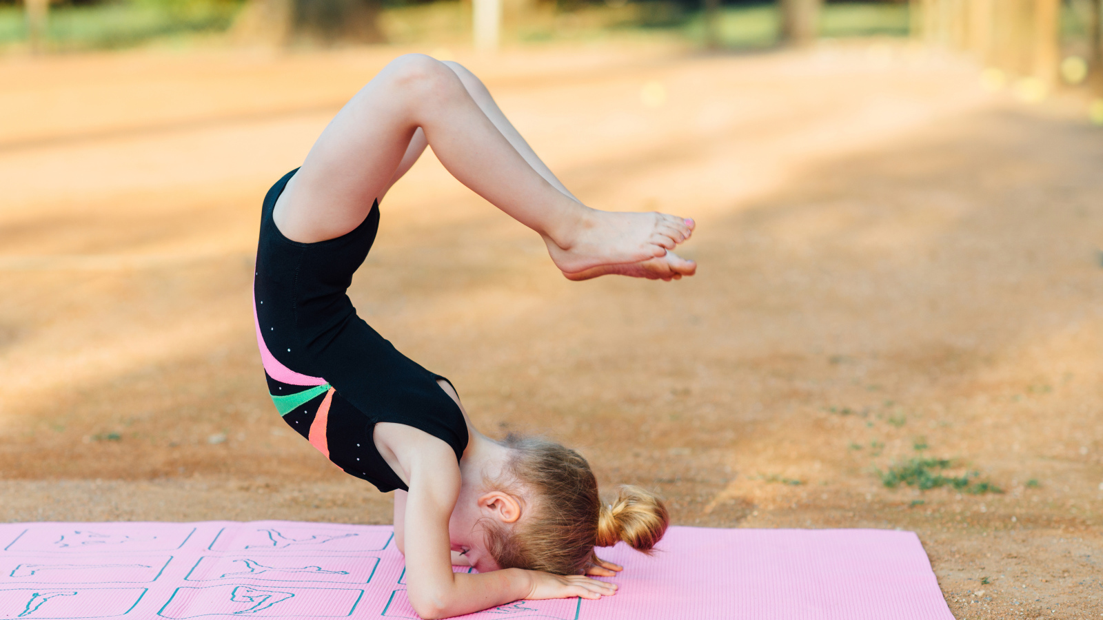 Маленькая девочка занимается гимнастикой