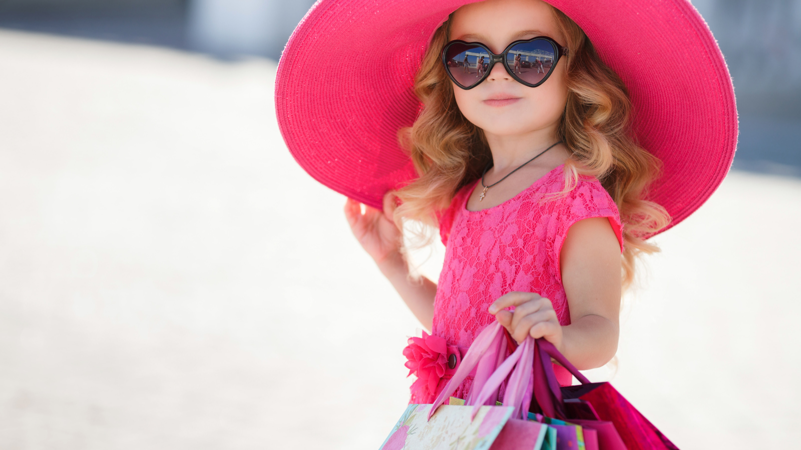 Маленькая девочка модница в большой розовой шляпе