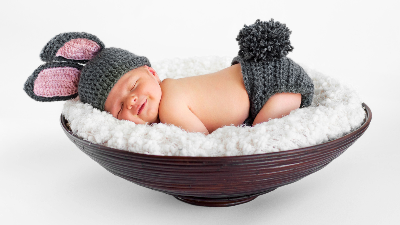 Маленький спящий грудной ребенок в вязаном костюме зайчика