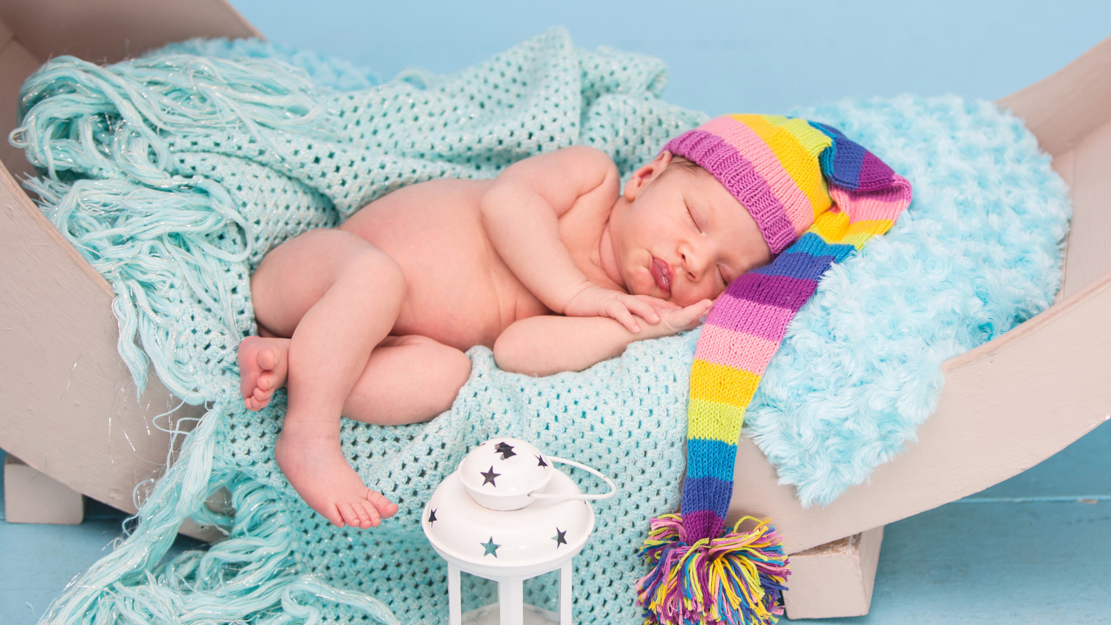 Спящий грудной ребенок в большой вязаной шапке