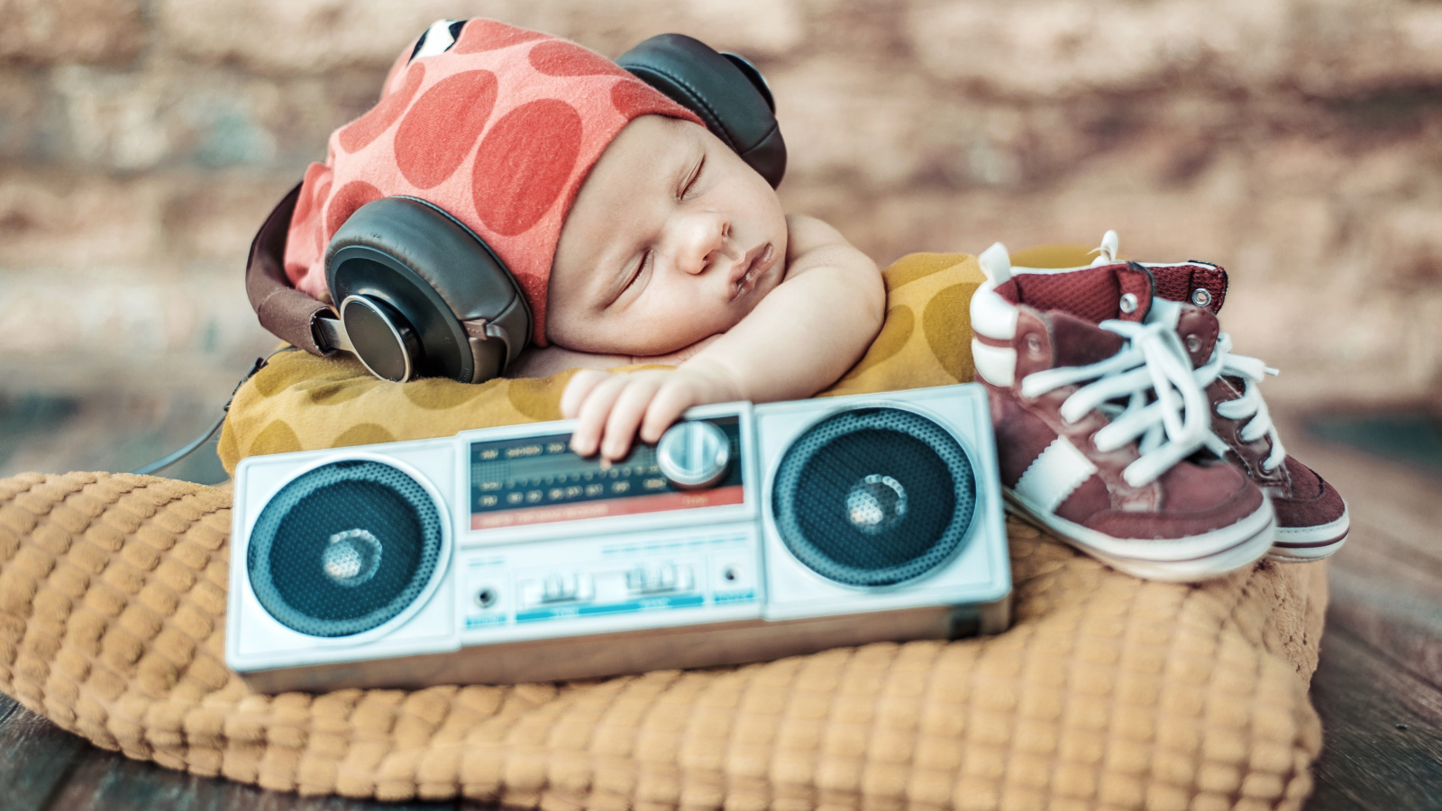 Спящий младенец в наушниках и с игрушечным магнитофоном