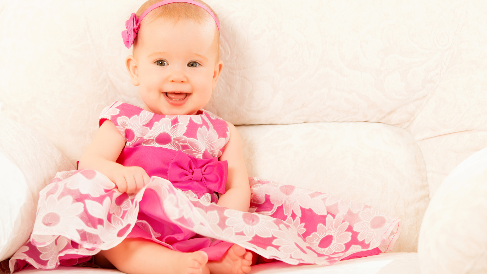 Улыбающаяся маленькая девочка в красивом розовом платье