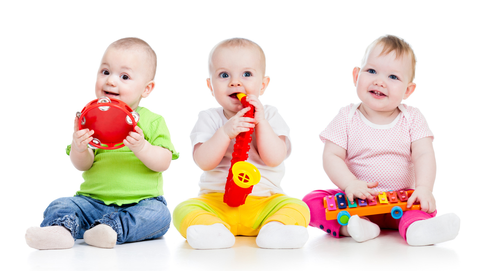 Три улыбающихся младенца играют на белом фоне
