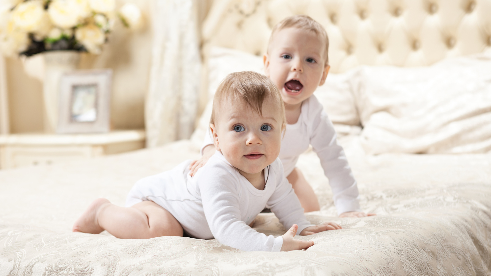 Два забавных младенца лежат на кровати