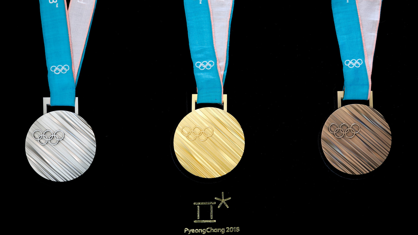 Три медали зимних Олимпийских игр 2018 на черном фоне