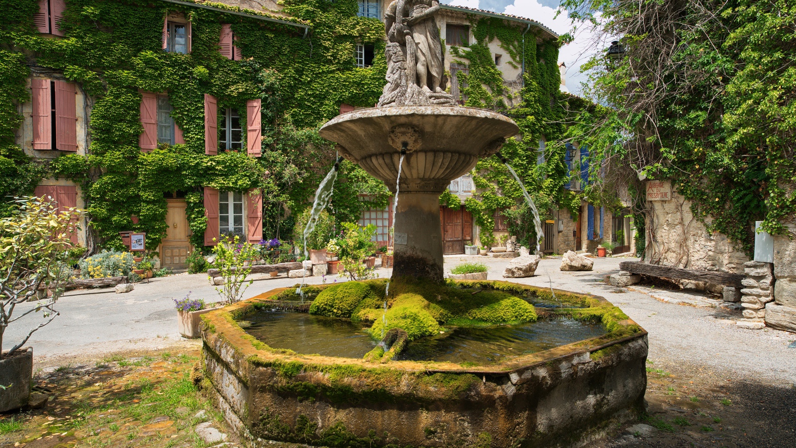 Ancient moss-covered fountain in the square of Segnon, France