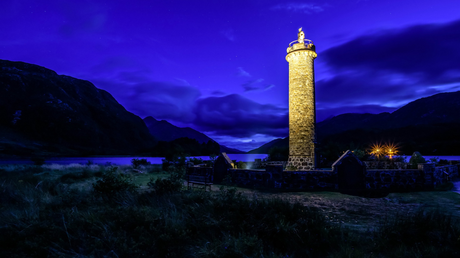 Ночной маяк у побережья на фоне гор, деревня Гленфиннан. Шотландия