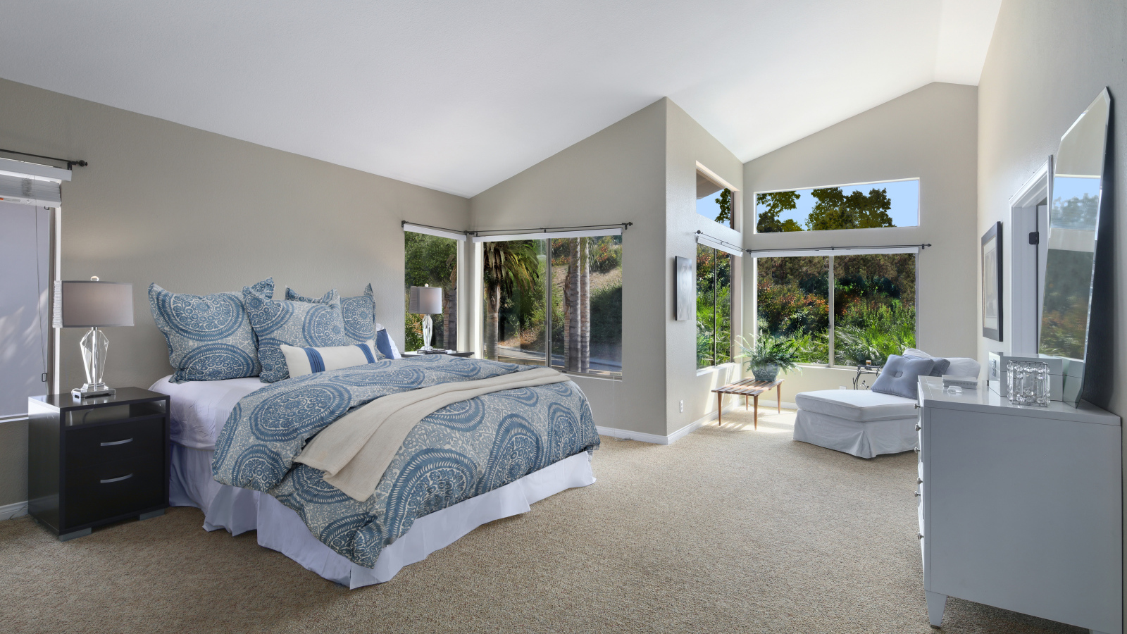 Уютная спальная комната в серых тонах с большими окнами