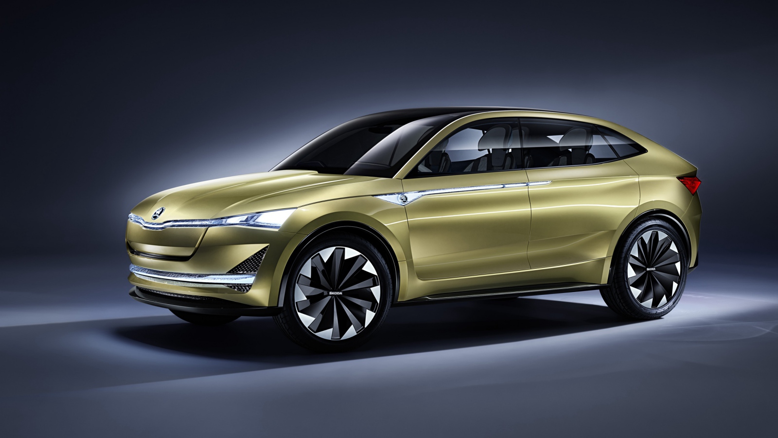 Электромобиль Skoda Vision E цвета золотой металлик на сером фоне