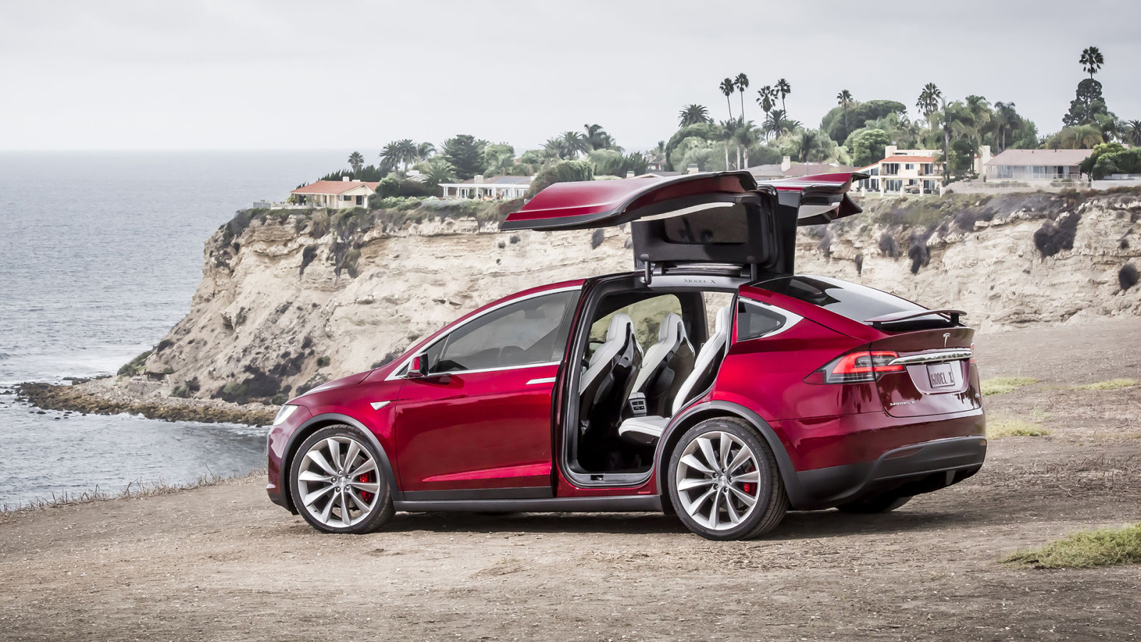 Красный электромобиль Тесла на берегу 
