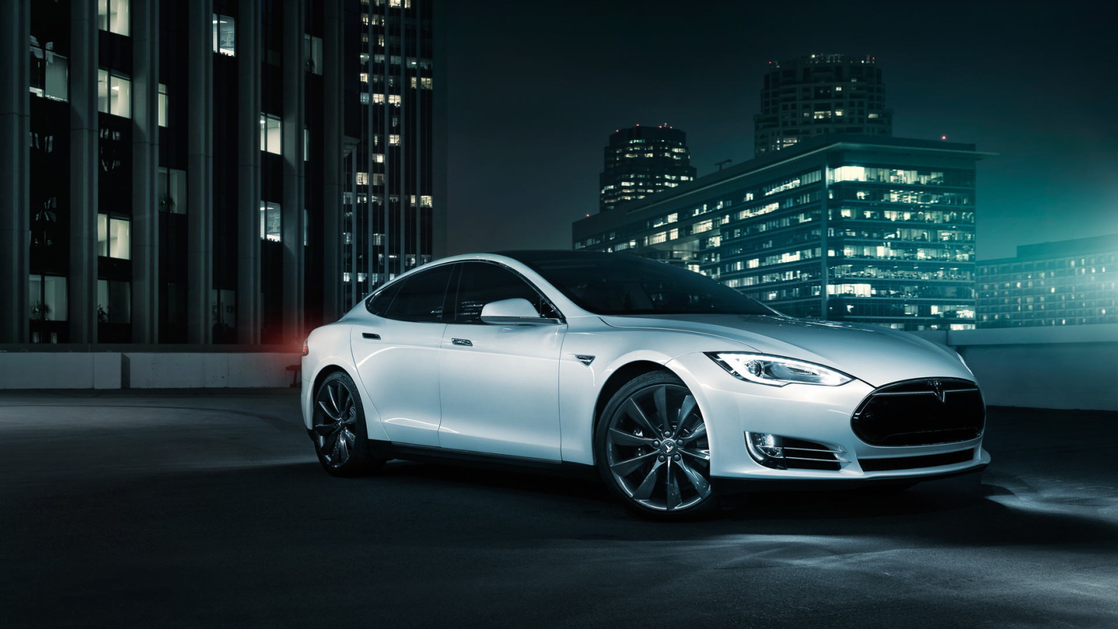 Белый электромобиль Тесла на фоне города 