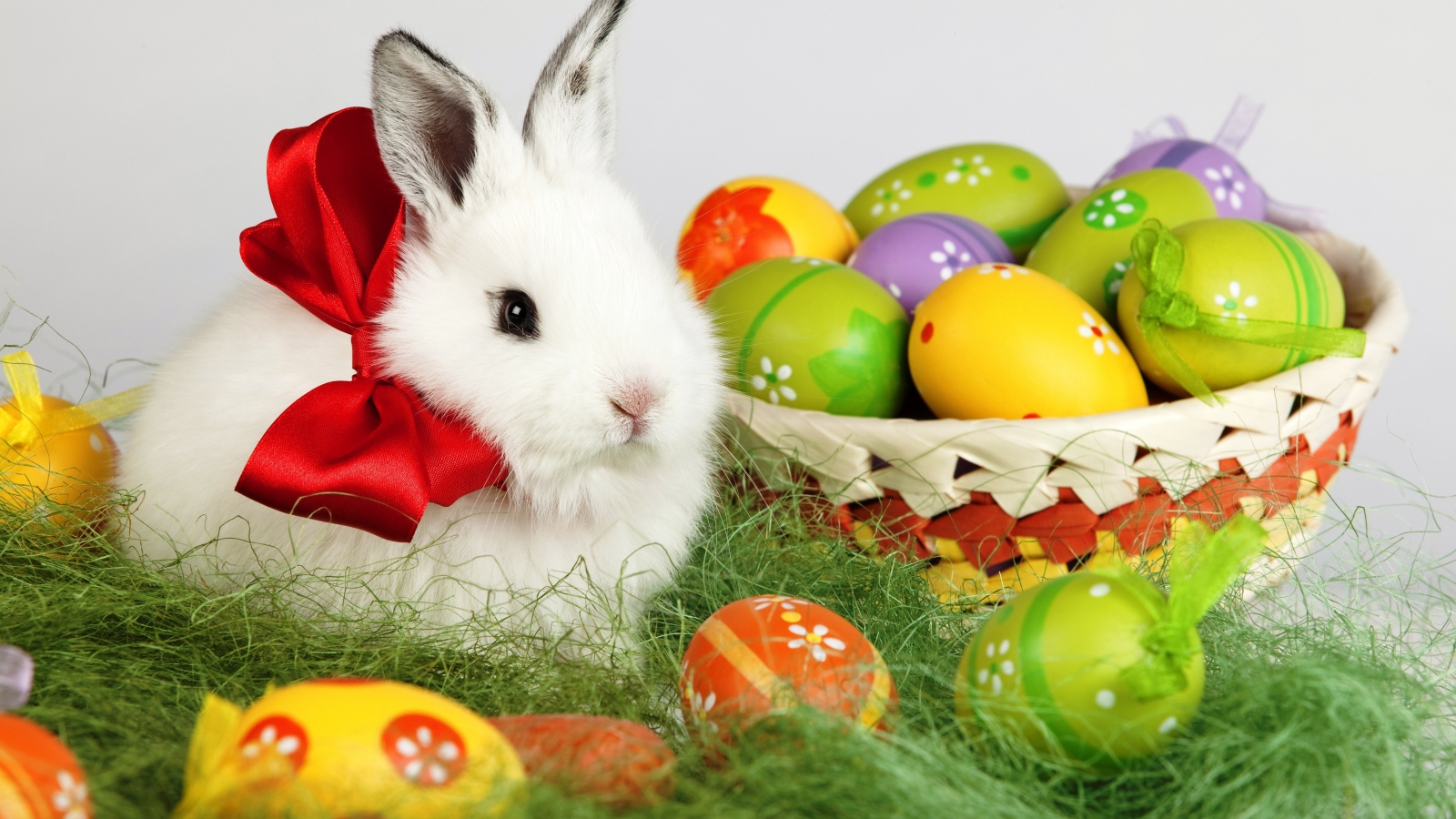 Fluffy white decorative rabbit with basket of Easter eggs
