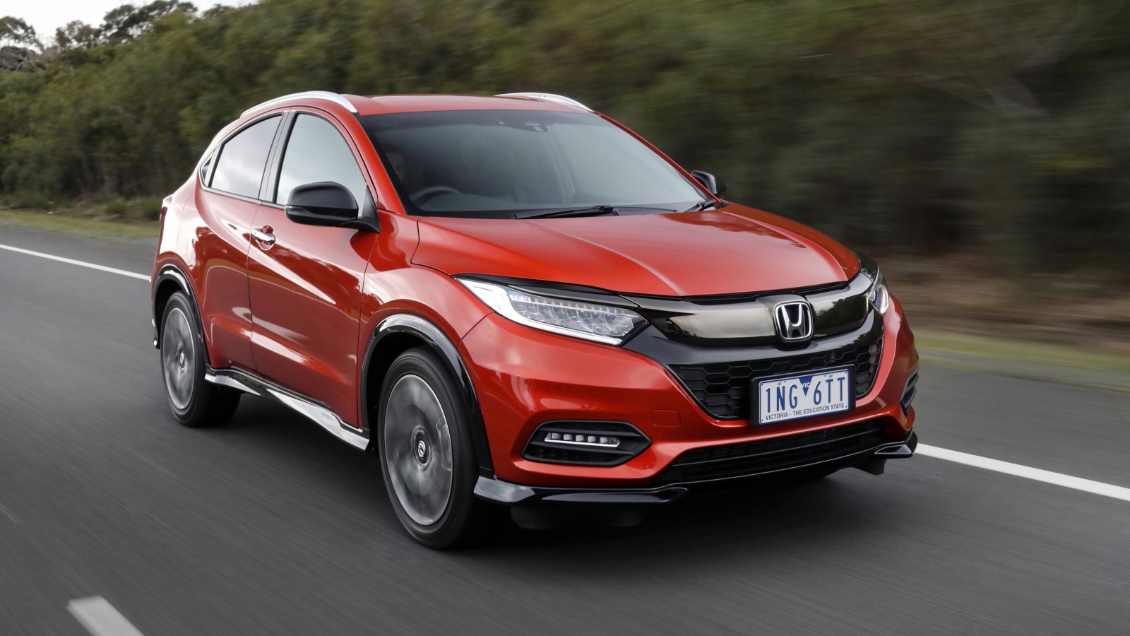 Красный автомобиль Honda HR-V RS 2019 года на трассе