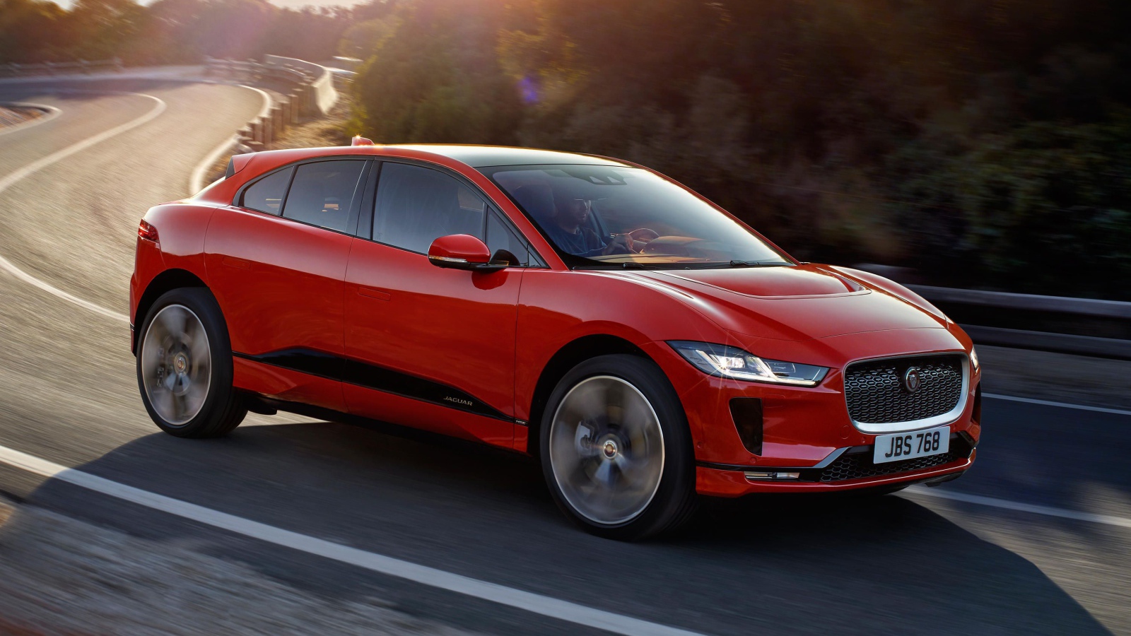 Красный автомобиль Jaguar I-Pace 2019 года на трассе 