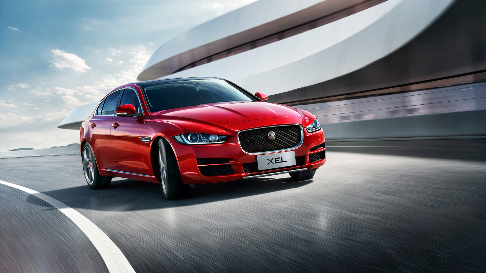 Красный автомобиль Jaguar XEL, 2018 на трассе
