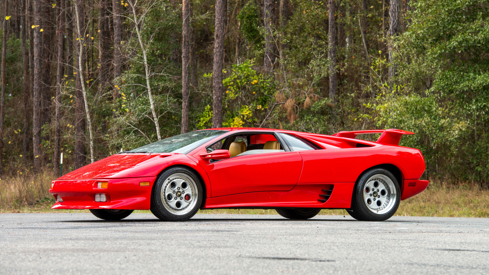 Красный спортивный автомобиль Lamborghini Diablo на фоне леса