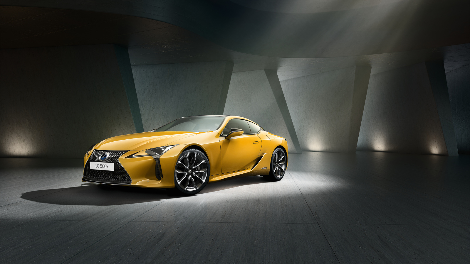 Желтый автомобиль Lexus LC 500 в сером здании