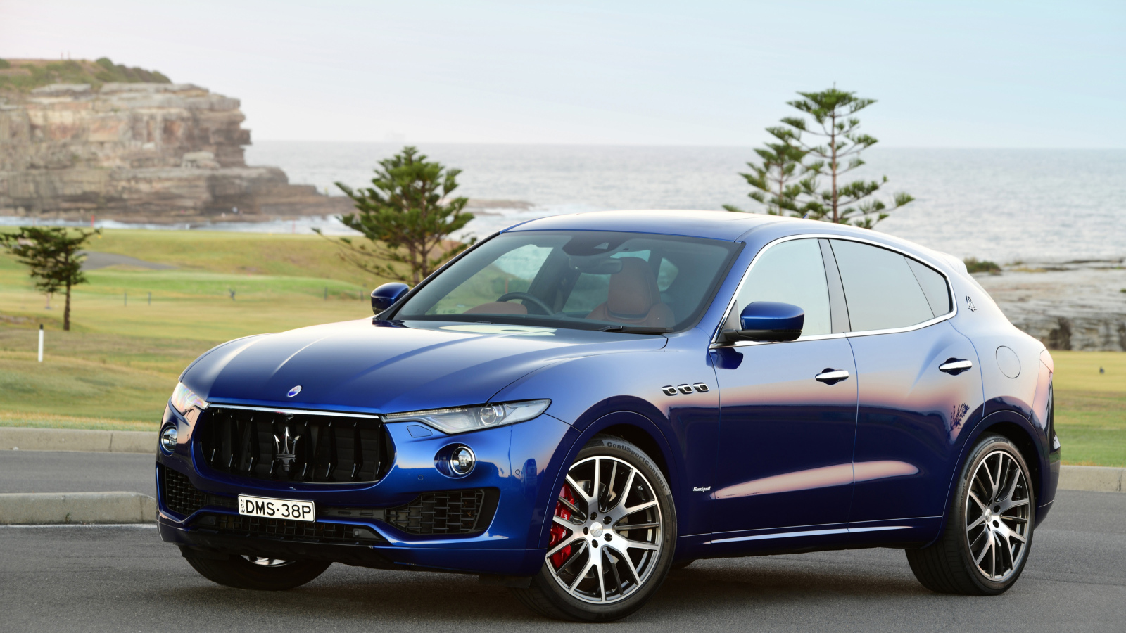 Синий автомобиль Maserati Levante на фоне океана 