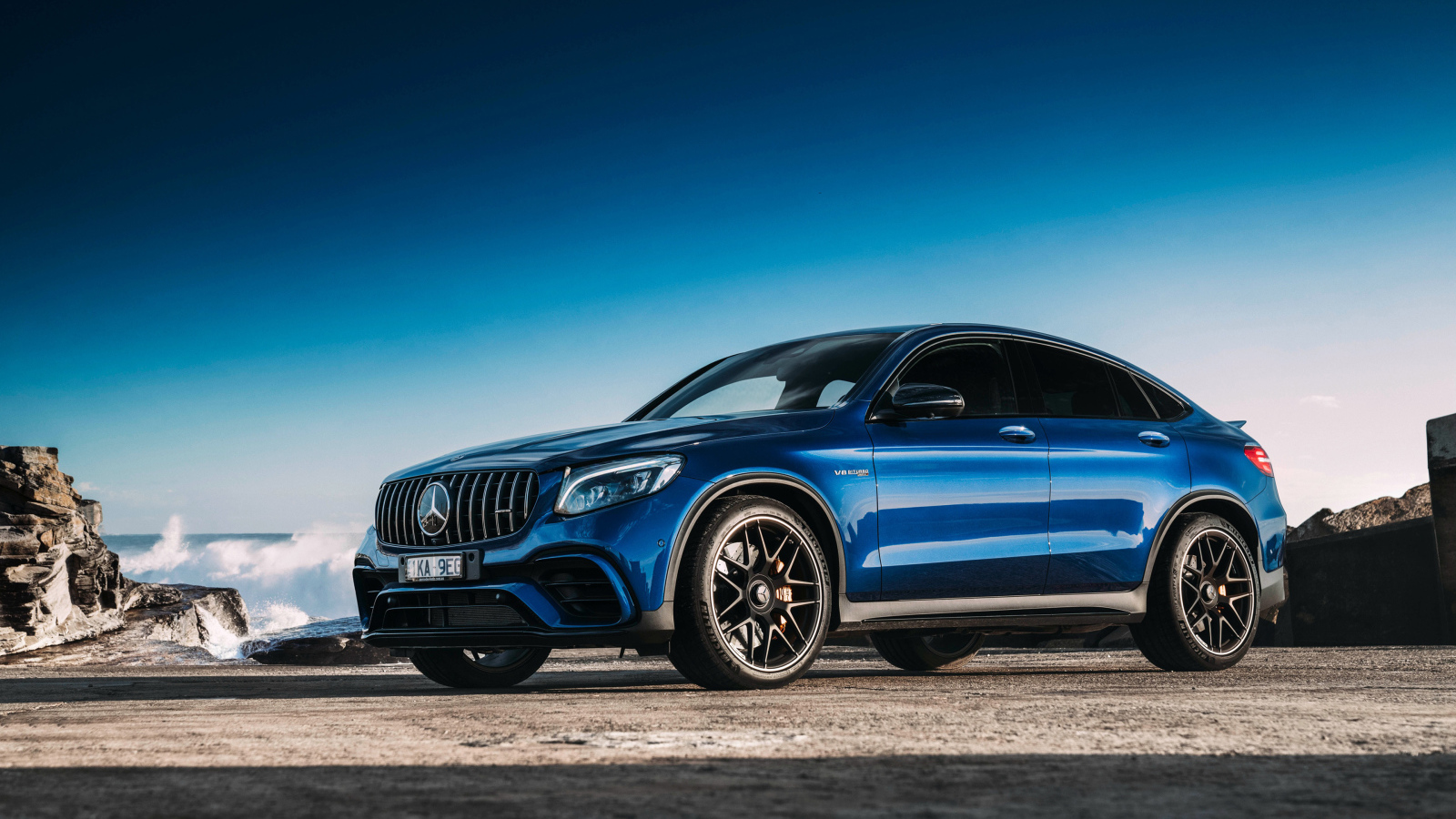 Синий автомобиль Mercedes GLC63 AMG, 2018 года вид сбоку