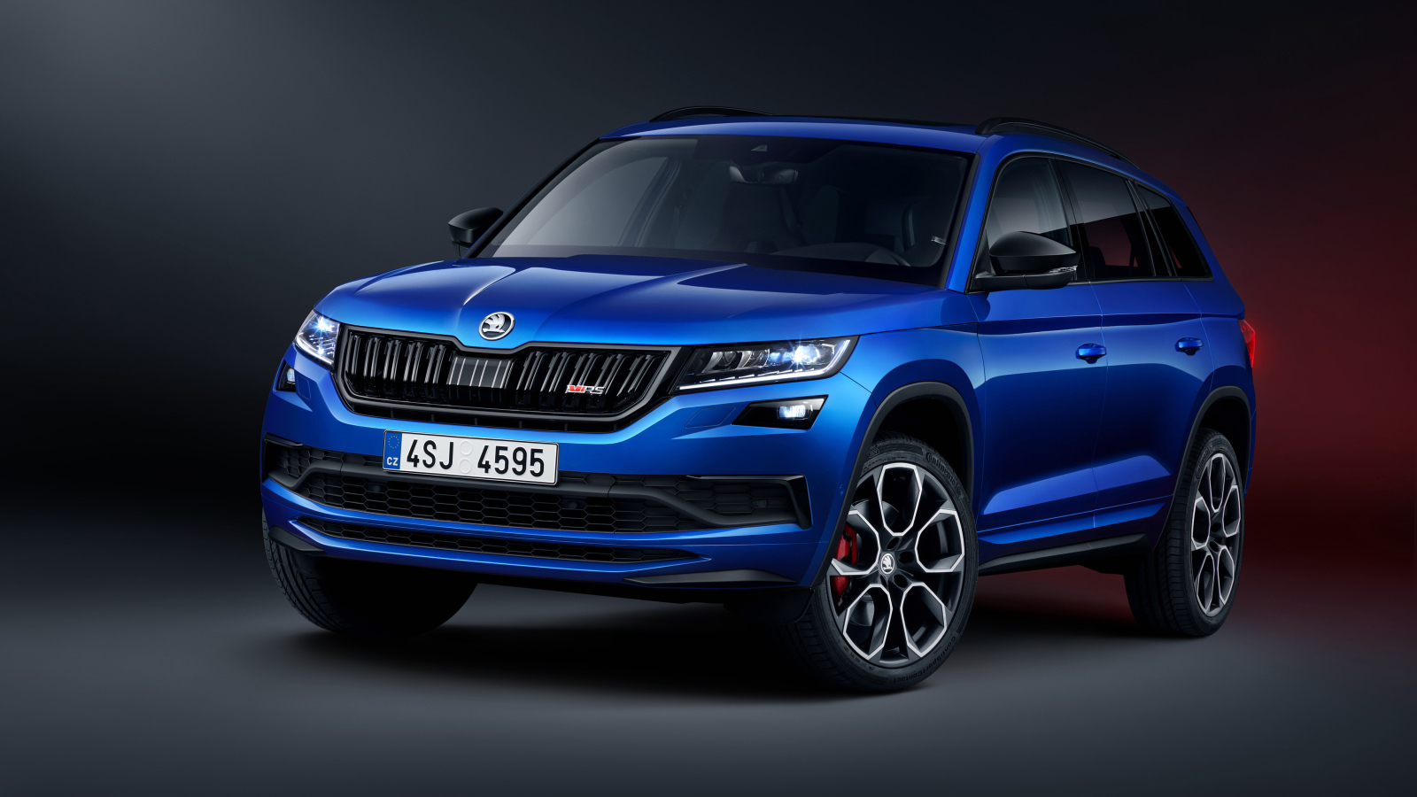Синий внедорожник Skoda Kodiaq RS 2019 года на сером фоне