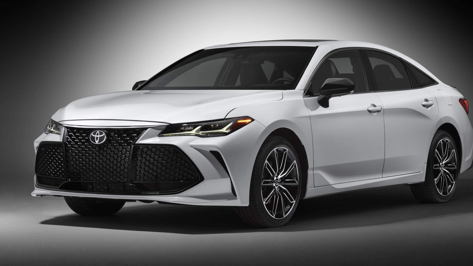 Белый автомобиль Toyota Avalon 2019 на сером фоне