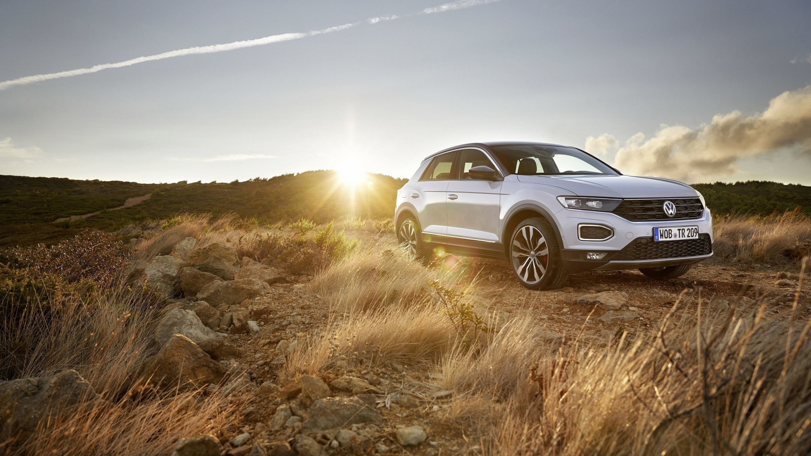 Серебристый внедорожник Volkswagen T-Roc, 2018 года на фоне солнца