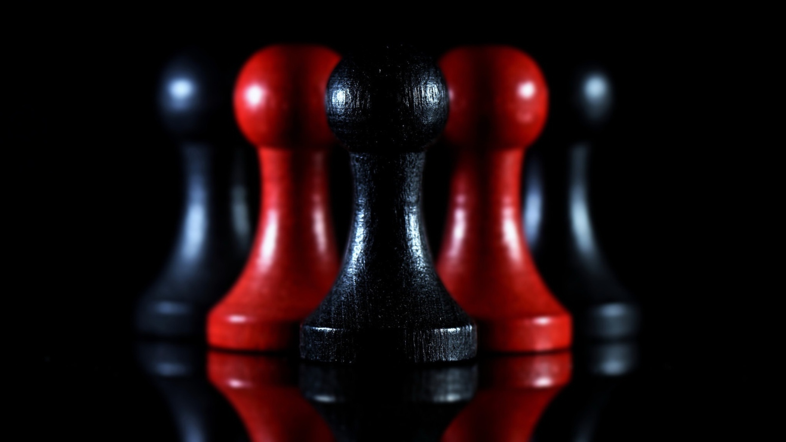 Красные и черные шахматные фигуры на черном фоне