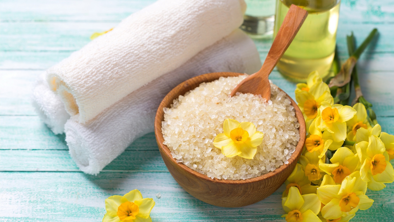 Соль с цветами нарцисса и полотенцем на столе