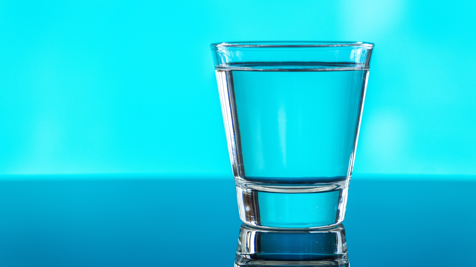 A glass of water on a blue background