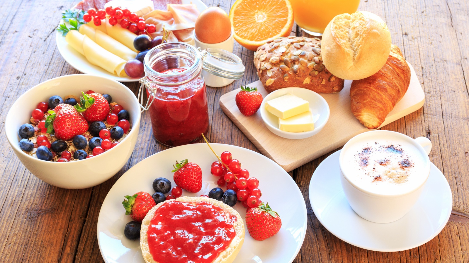 Аппетитный завтрак на столе с бутербродами, кофе и ягодами