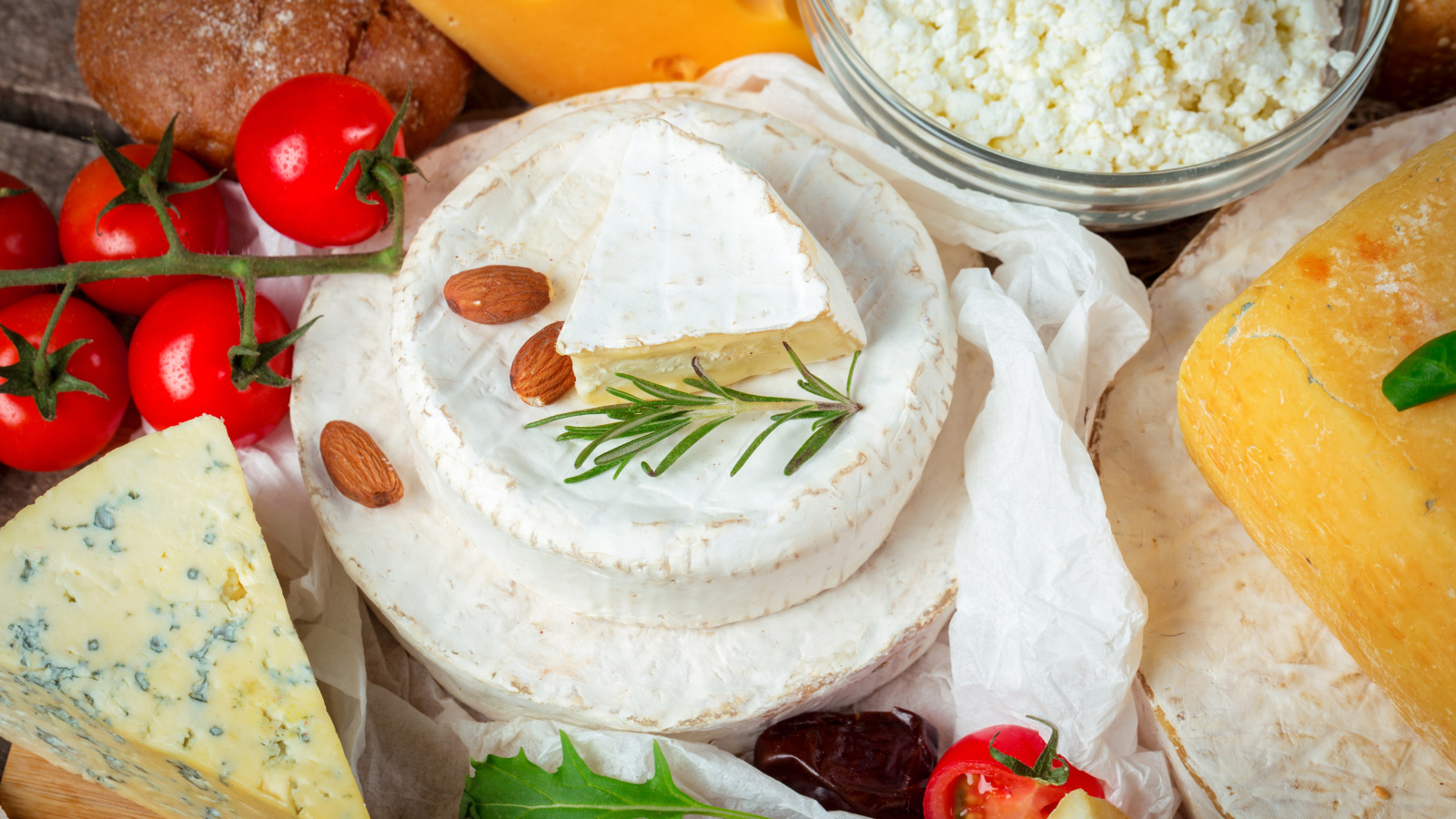 Разные виды сыра на столе с помидорами 