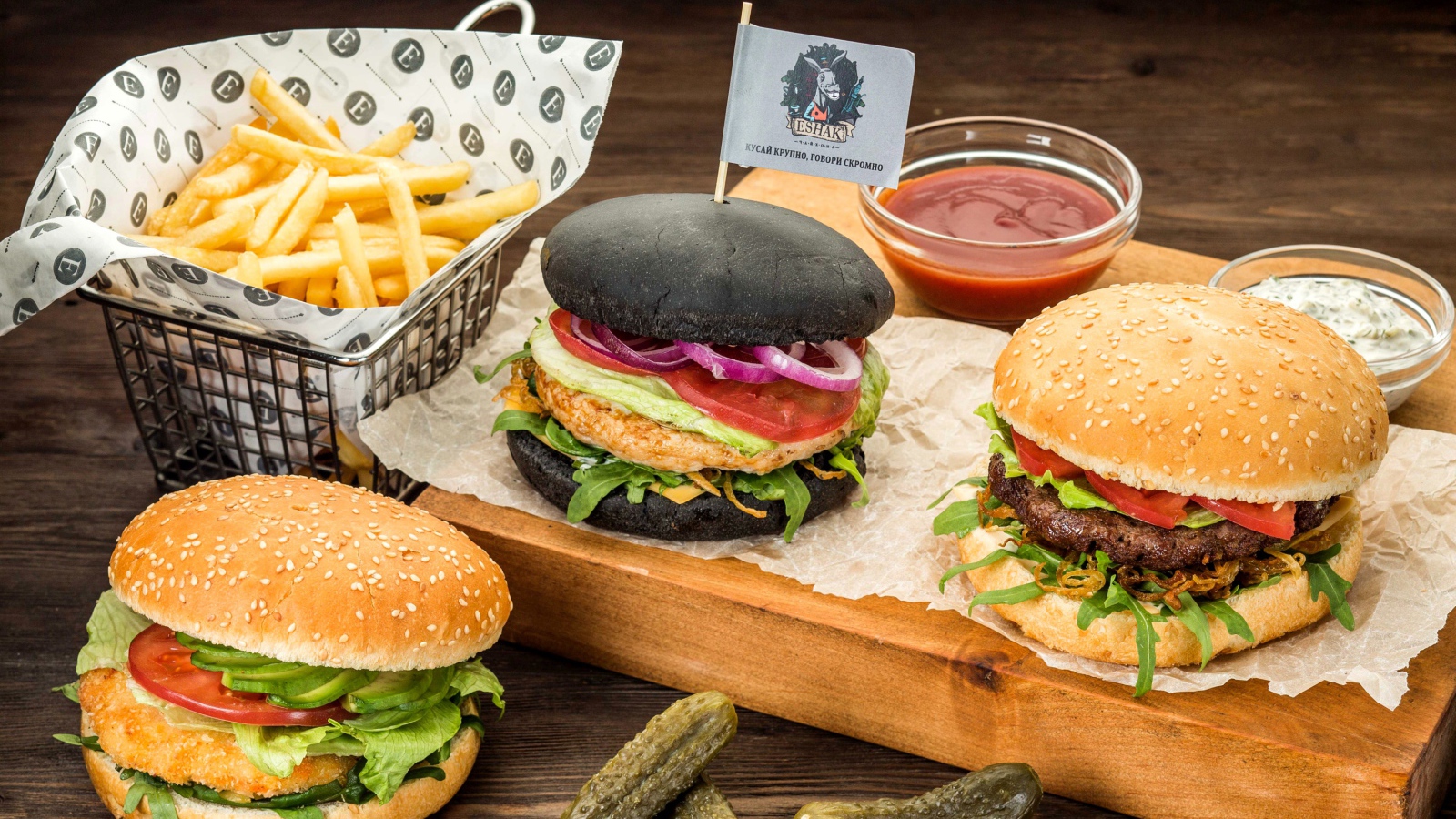 Гамбургеры с картофелем фри и солеными огурцами на столе 