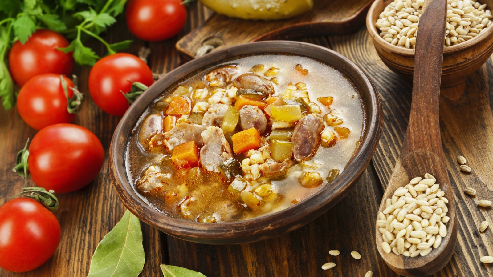 Перловый суп с сердечками на столе с помидорами 