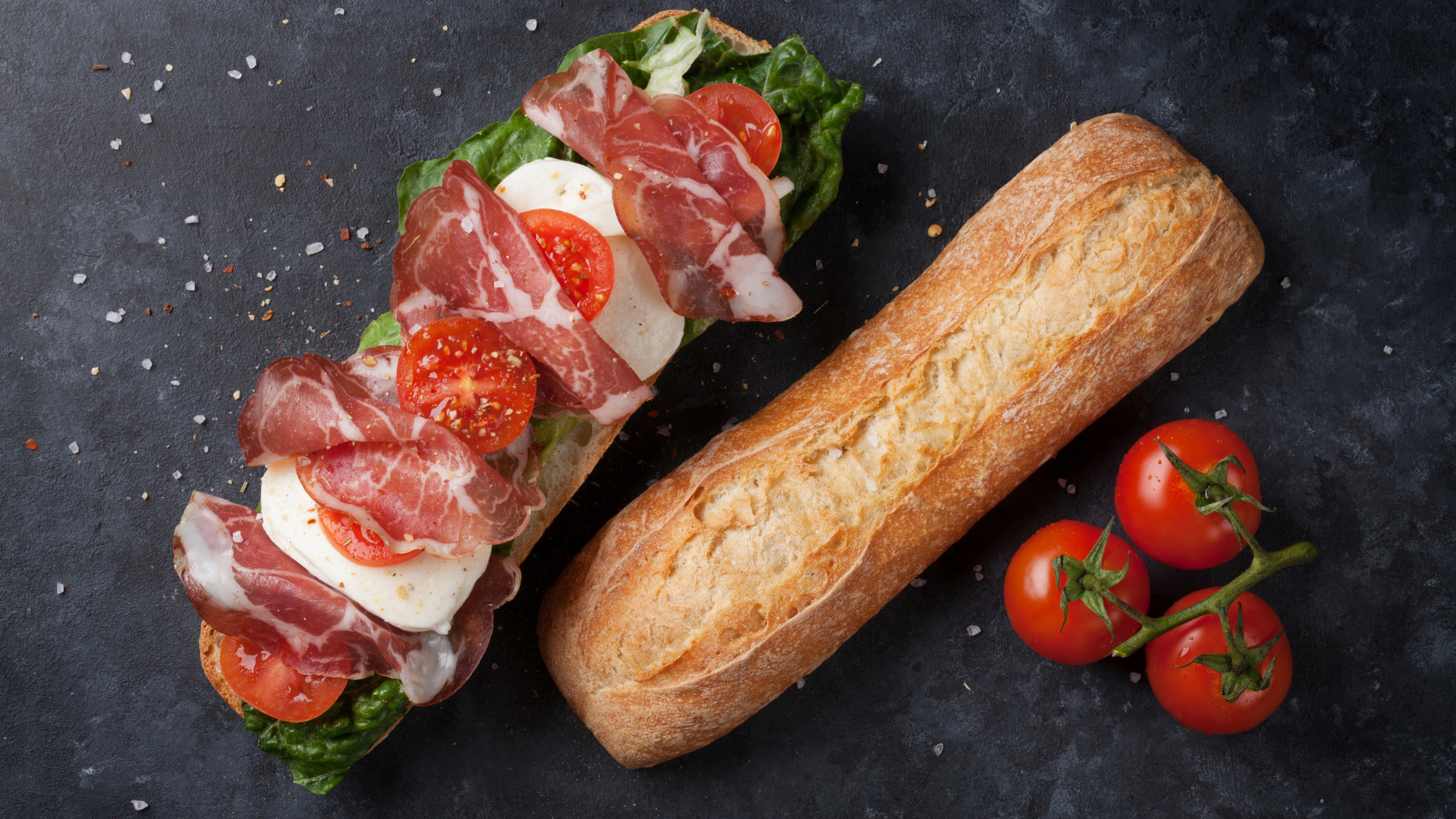 Бутерброд с ветчиной, помидорами, яйцом и листьями салата