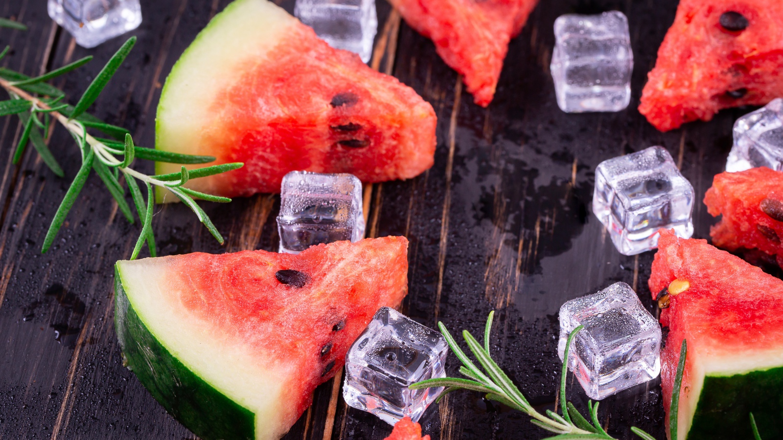 Кусочки арбуза на столе со льдом и розмарином