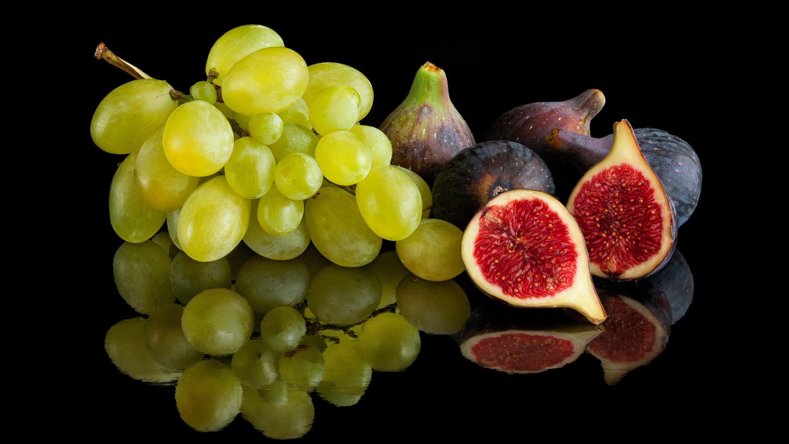 Белый виноград и инжир на черном фоне